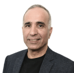 Portrait of a middle-aged man with short gray hair, wearing a dark blazer over a black shirt, smiling at the camera against a plain white background—perfect for introducing topics on the evolving cybersecurity landscape in your next video.