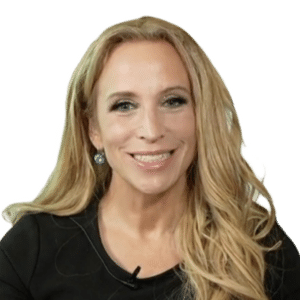 A woman with long blonde hair, wearing a black top and earrings, smiles at the camera against a plain white background, ready to discuss the evolving cybersecurity landscape.