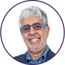 Smiling older man with gray hair, a short beard, blue glasses, and a blue shirt with a blazer, shown in a circular frame on a white background—perfect for Cybericon2024 profiles.