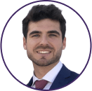 Headshot of a young man with dark hair and beard, wearing a dark suit, white shirt, and red tie, smiling at the camera against a white background—perfect for a professional Cybericon2024 profile.