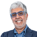 Smiling older man with gray hair, glasses, and a beard wearing a blue blazer and light blue shirt, posed against a plain white background—perfect for professional profiles or Cybericon2024 event materials.