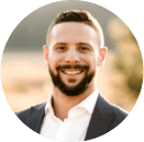 A man with a beard, wearing a suit jacket and white shirt, smiling outdoors with a blurred background—reflecting confidence in the fight against financial crime and cybersecurity threats.