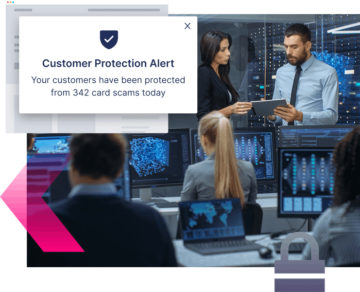 People in an office with computer monitors view a pop-up alert stating customers were protected from 342 credit card scams today.